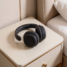 Black over-ear wireless headphones on bedside table