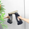 Handheld window vacuum cleaner in use on bathroom mirror