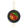 Cream-handled non-stick frying pan with grilled vegetables, top view