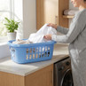 Blue plastic laundry basket with mixed washing on worktop in utility room