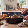 Roast beef with potatoes and rosemary in roasting tin, served with Yorkshire puddings
