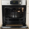 Black oval roasting pan inside electric oven with door open