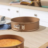 Gold non-stick springform cake tin on kitchen worktop, baking pan open and empty