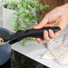 Removable black handle on blue speckled saucepan with pasta, shown in kitchen setting
