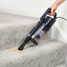 Handheld vacuum cleaning crumbs from carpeted stairs