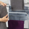 Assorted coloured towels on airer in bathroom, including grey, blue, purple and white
