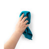 Hand holding a teal microfibre cloth wiping a white surface