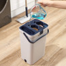 Grey mop bucket with handle, water and cleaning solution being poured in