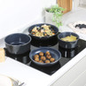 Set of four non-stick blue saucepans and frying pan on induction hob, some filled with food