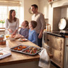 Non-stick grey baking tray with roasted vegetables on kitchen worktop, family cooking in background