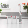 Electric cleaning brush with three replacement heads, shown on kitchen worktop