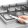 Electric cleaning brush scrubbing gas hob, showing spot cleaning action.