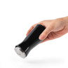 Black Salter salt shaker held in hand, angled for use