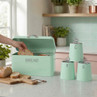 Mint green bread bin with lid open and sliced loaf, matching tea, coffee, sugar canisters