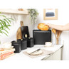 Black bread bin with loaf of bread, modern kitchen setting