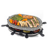 Electric raclette grill with granite stone, cooking salmon, peppers, baby corn, and asparagus