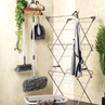 Indoor laundry set with drying rack, cleaning tools, and laundry basket in home setting
