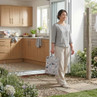 Laundry bag with dog print, held by person in garden, kitchen background