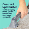 Handheld carpet cleaner removing red wine spill from light fabric sofa