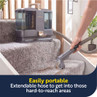 Portable carpet cleaner with extendable hose shown cleaning stairs
