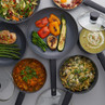Non-stick cookware set filled with assorted cooked meals, overhead view