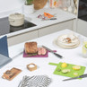 Set of colour-coded chopping boards with knives on kitchen counter, ready for food prep
