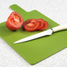 White-handled kitchen knife and sliced tomato on green chopping board