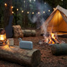 Blue portable speaker on log by campfire and tent in forest, outdoor setting