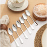 Set of six silver dessert spoons on a table setting