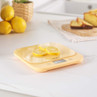 Yellow digital kitchen scale with lemon slices, shown on countertop