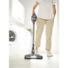 Cordless stick vacuum cleaner with LED lights in use on hard floor