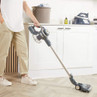 Cordless stick vacuum cleaner in use on kitchen floor