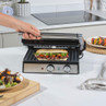 Stainless steel panini press with grilled sandwich in modern kitchen setting