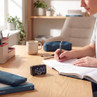 Digital timer clock on desk beside notebooks and stationery in study setting