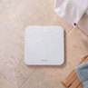 White digital bathroom scale on tiled floor, display shows 0.0kg