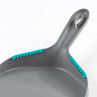 Grey dustpan with teal rubber teeth on edge, shown close-up
