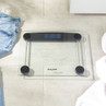Digital glass bathroom scale with black accents on light tiled floor