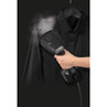 Handheld clothes steamer removing creases from a black shirt on a hanger