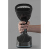 Hand holding black handheld garment steamer with brush attachment, shown from front.