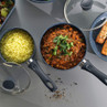 Set of non-stick saucepans with lids, shown cooking curry, rice, and salmon.