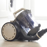 Bagless cylinder vacuum cleaner shown on wooden floor, multi-cyclonic model.