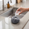 Person filling compact grey humidifier with water by kitchen sink