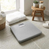 Silver mechanical bathroom scale on tiled floor, angled view