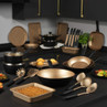 Kitchen cookware and utensils set, gold and black, displayed on countertop