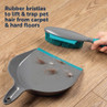 Grey rubber pet hair brush and dustpan set lifting pet hair from hard floor.
