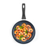 Non-stick frying pan with cooked prawns and parsley, shown from above