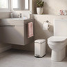 White rectangular pedal bin in modern bathroom, positioned beside toilet