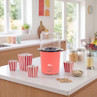 Red popcorn maker with striped tubs on kitchen counter, ideal for home movie nights.