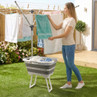 Grey collapsible laundry basket with legs in garden, beside rotary washing line.