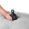 Beldray black handheld fabric shaver with rose gold trim in use on grey cushion